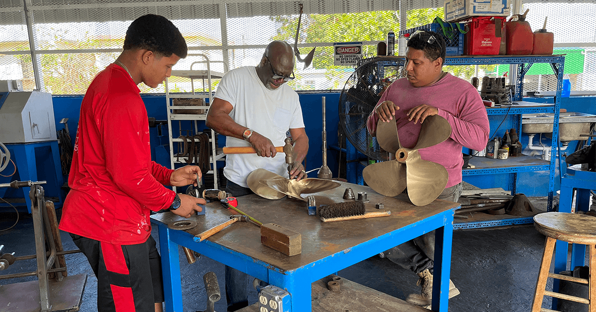 Tree motors with propellers being repair on a dock